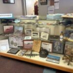 photo of welcome display desk showing different old photo's, model airplanes, and aviation knickknacks.