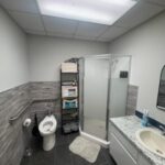 pilots lounge5 photo shows the restroom area with toilet, shower, sink and counter