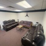 photo of pilots lounge with three brown leather couches